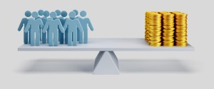 Balance scale comparing employees with stacks of coins